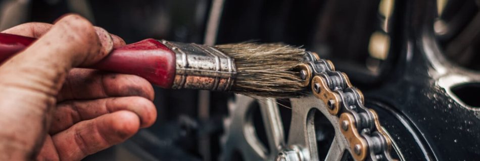 バイクチェーンのメンテナンスをする人