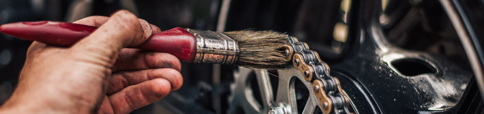 バイクチェーンのメンテナンスをする人